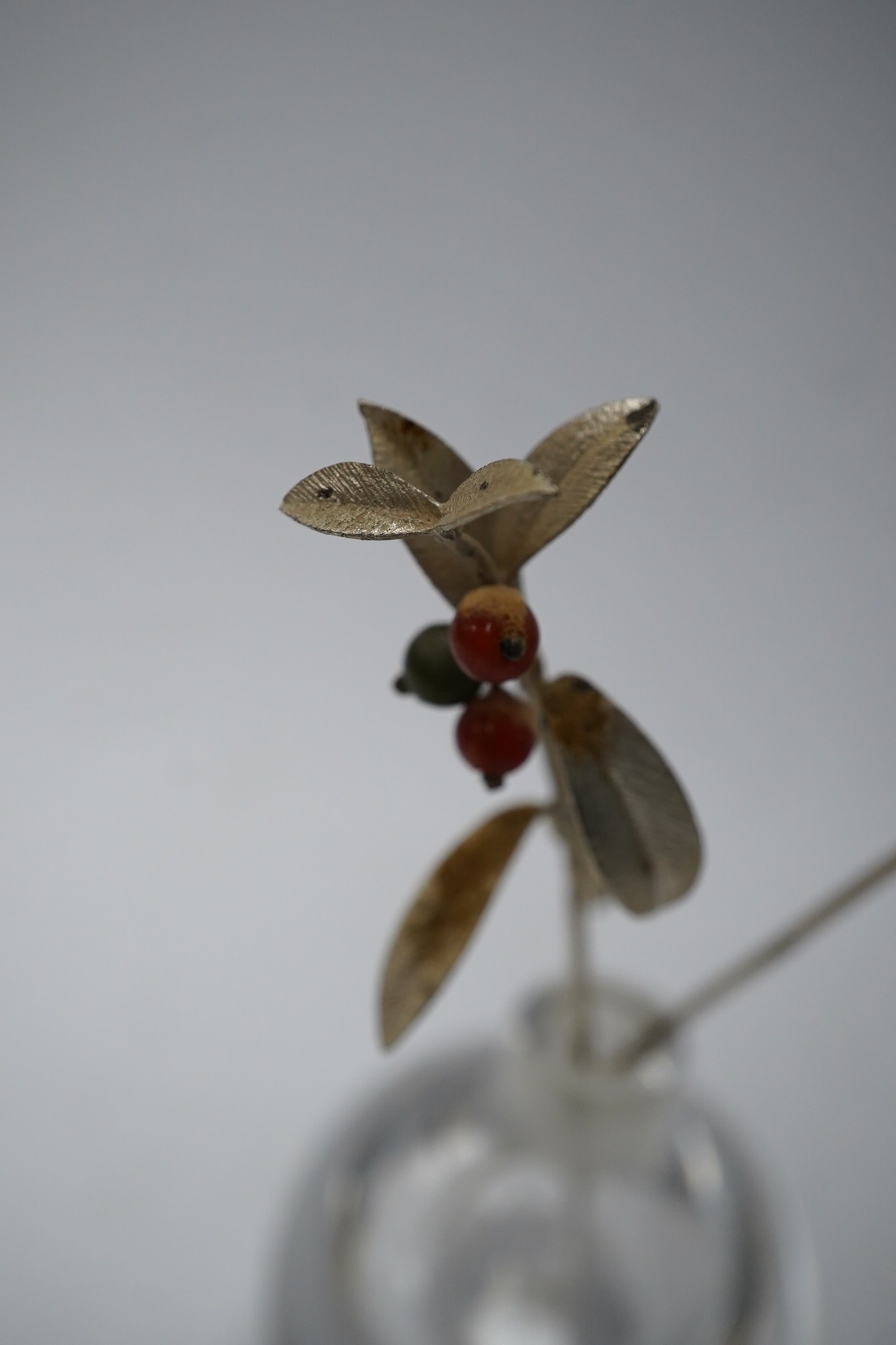 A 1980's silver gilt holly sprig and similar carnation, 15.7cm, in an Orrefors vase ornament, Condition - fair to good